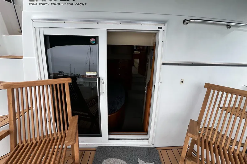 Slide: The Image of 2003 Carver 444 Cockpit Motor Yacht with wooden chairs and sliding door. - 64