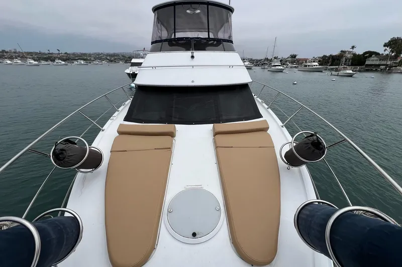 Slide: The Image of 2003 Carver 444 Cockpit Motor Yacht with tan sun loungers on deck, docked in marina. - 8