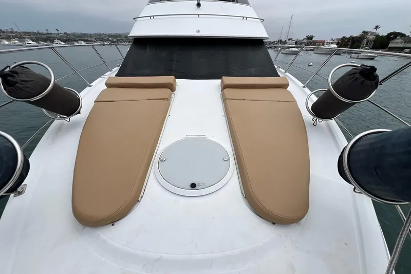Slide: The Image of 2003 Carver 444 Cockpit Motor Yacht with tan sun pads on deck, docked in marina. - 9