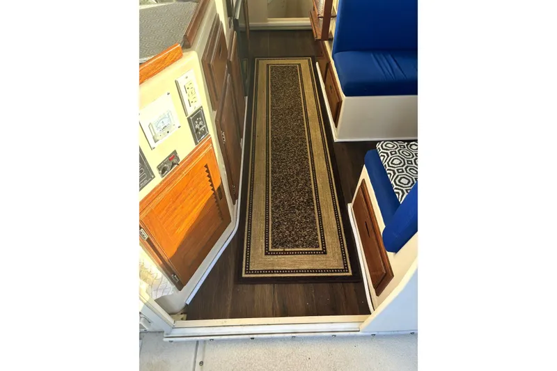 Slide: The Image of Interior of 1999 Rosborough 246 boat with wooden cabinets and patterned rug. - 14