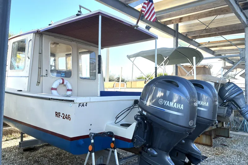 Slide: The Image of 1999 Rosborough 246 boat with Yamaha outboard motors, docked under a canopy. - 2