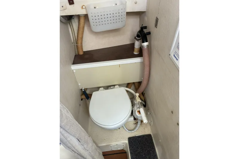 Slide: The Image of 1999 Rosborough 246 boat interior with compact marine toilet setup. - 8