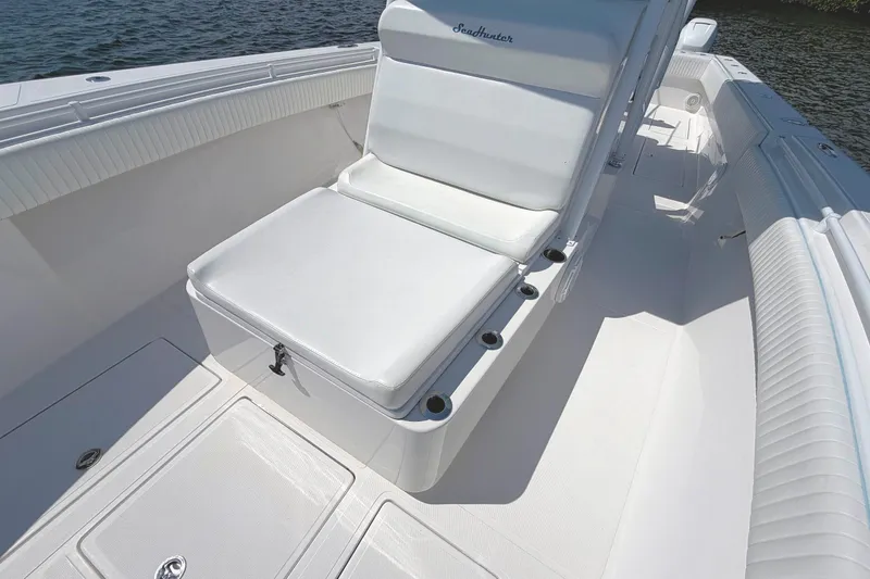 Slide: The Image of 2017 SeaHunter 39 boat interior with white seating and deck, near water. - 16
