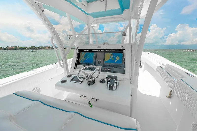 Slide: The Image of 2017 SeaHunter 39 boat cockpit with dual navigation screens, steering wheel, and ocean view. - 9