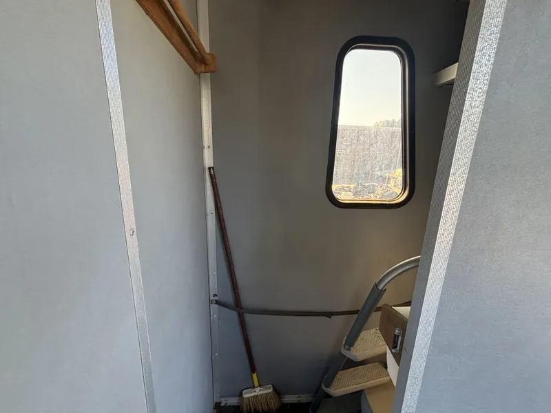 Slide: The Image of Interior of a 1990 Sun Tracker Party Hut 28 with window and broom. - 22