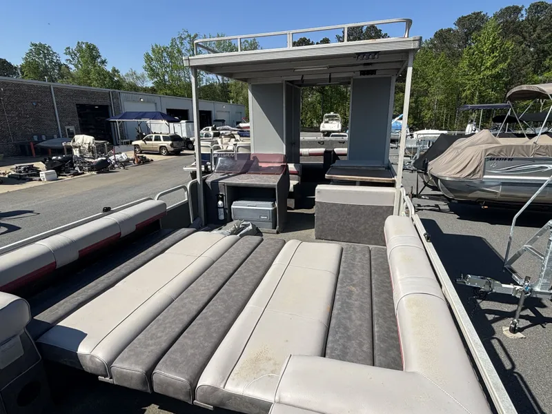 Slide: The Image of 1990 Sun Tracker Party Hut 28 pontoon boat in a parking lot. - 6