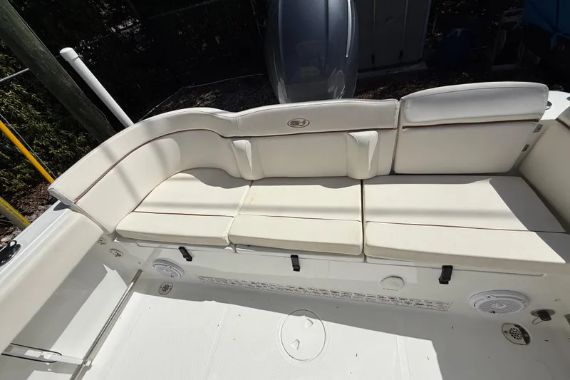 Slide: The Image of 2020 Sea Hunt Ultra 225 boat with white cushioned seating and clean deck. - 17