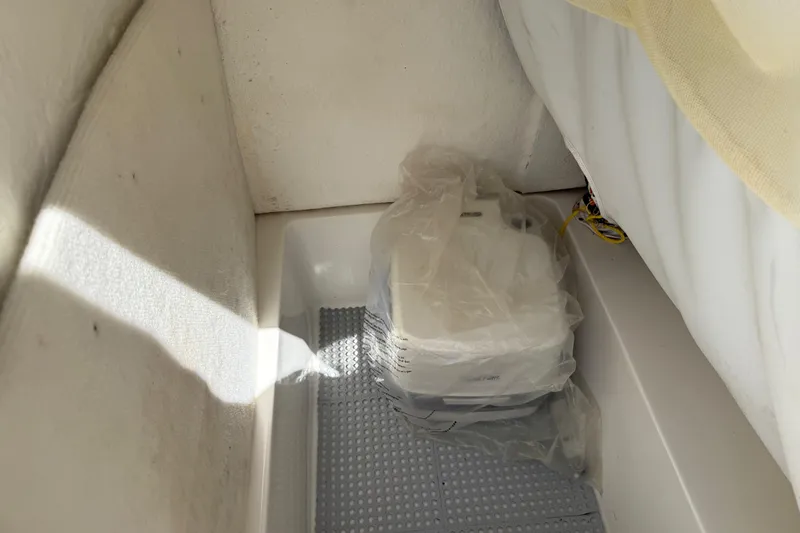 Slide: The Image of 2020 Sea Hunt Ultra 225 interior with covered equipment in storage compartment. - 23