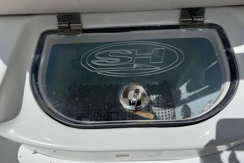 Slide: The Image of Sea Hunt Ultra 225 2020 boat compartment with SH logo on transparent lid. - 28