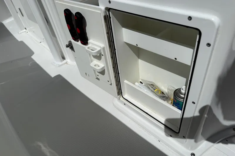 Slide: The Image of 2020 Sea Hunt Ultra 225 boat storage compartment with tools and spray can. - 31
