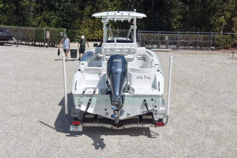 Slide: The Image of 2020 Sea Hunt Ultra 225 boat with outboard motor in a gravel lot. - 4