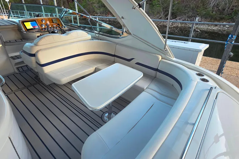 Slide: The Image of 2007 Formula 370 Super Sport boat interior with seating and table, docked by water. - 13