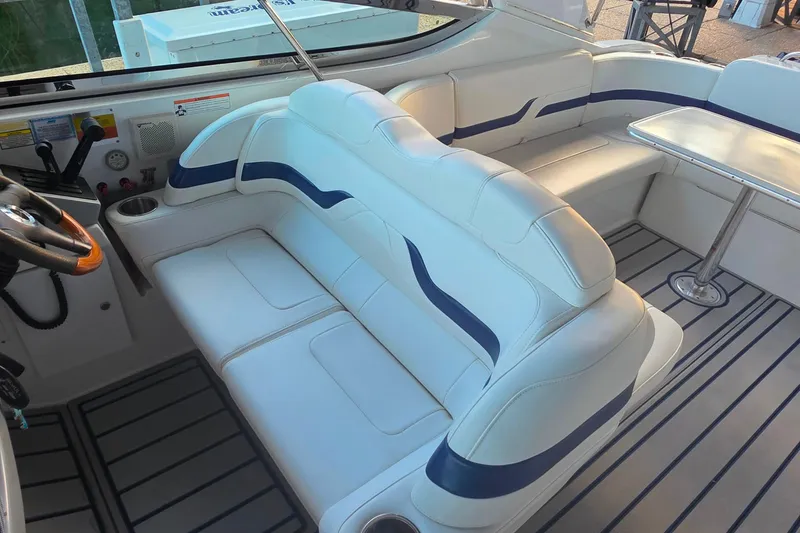 Slide: The Image of 2007 Formula 370 Super Sport boat interior with white and blue seating, steering wheel, and table. - 19