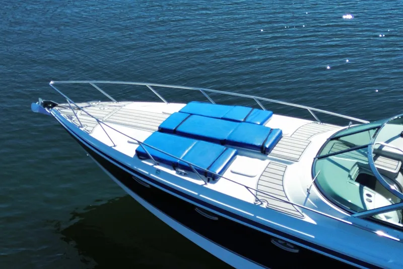 Slide: The Image of 2007 Formula 370 Super Sport boat with blue sunbeds on calm water. - 8