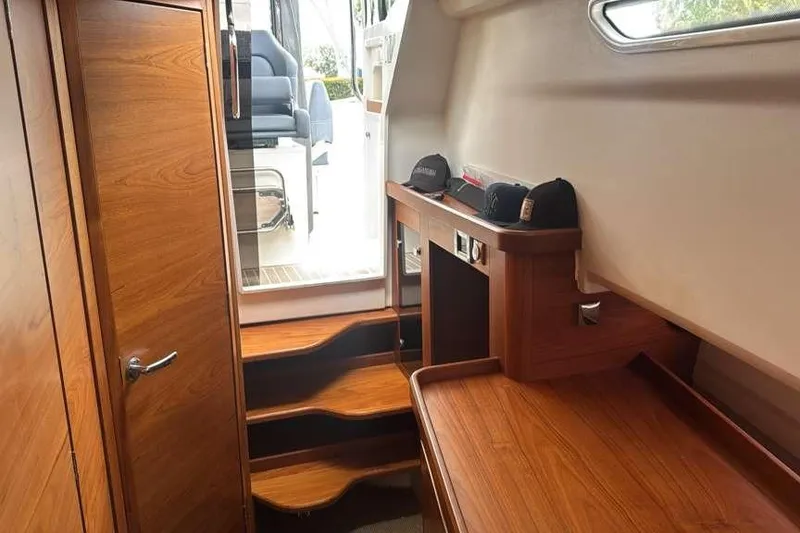 Slide: The Image of Interior of 2021 Nimbus T11 boat with wooden cabinetry and steps. - 8