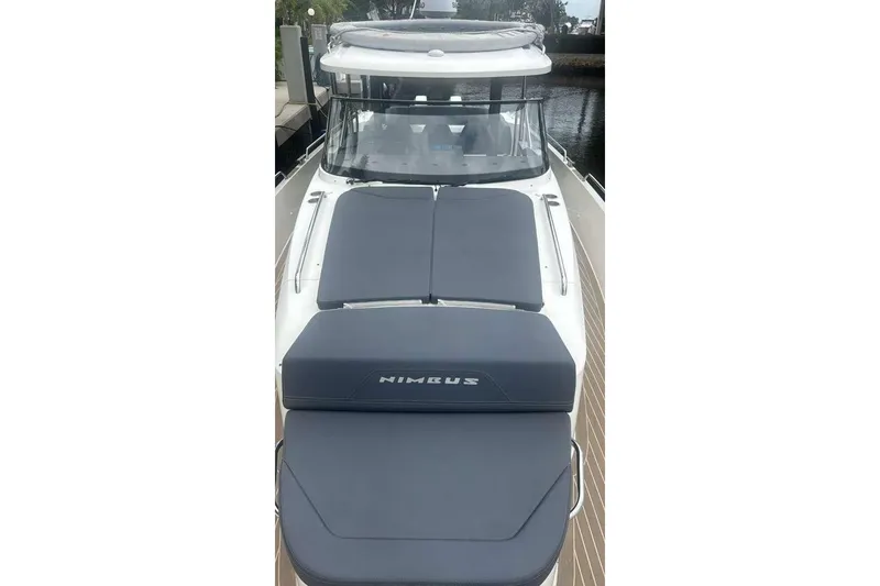 Slide: The Image of 2021 Nimbus T11 boat with cushioned deck, docked by the water. - 11