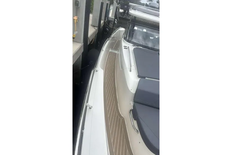 Slide: The Image of 2021 Nimbus T11 boat docked, featuring sleek design and spacious deck layout. - 13