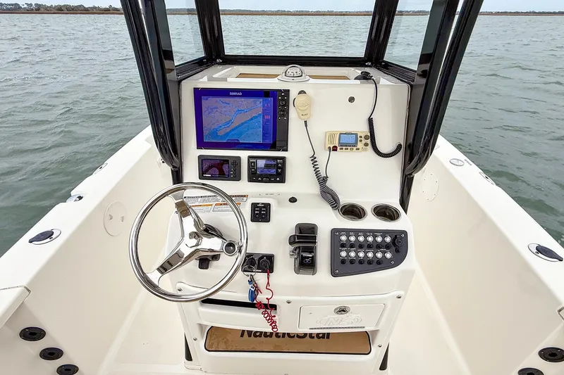 Slide: The Image of 2020 NauticStar 251 Hybrid boat console with navigation equipment and steering wheel. - 13