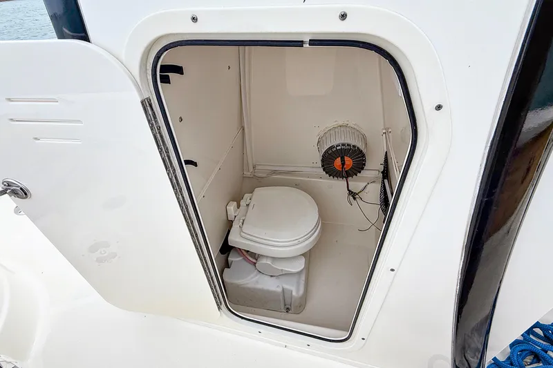 Slide: The Image of 2020 NauticStar 251 Hybrid boat interior with compact marine toilet. - 20