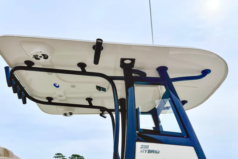 Slide: The Image of 2020 NauticStar 251 Hybrid boat T-top with rod holders and electronics. - 24