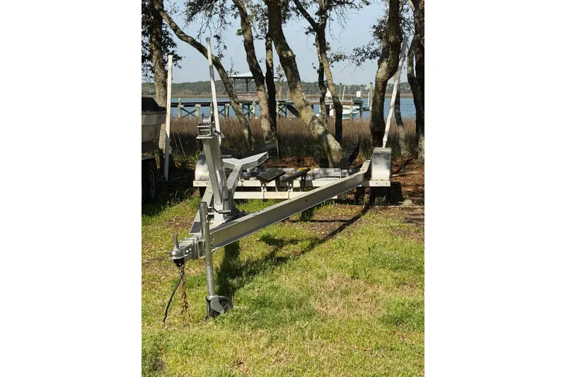 Slide: The Image of Boat trailer parked on grass near trees, designed for 2020 NauticStar 251 Hybrid. - 25