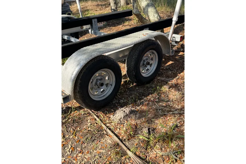 Slide: The Image of Trailer for 2020 NauticStar 251 Hybrid boat on grassy ground. - 27