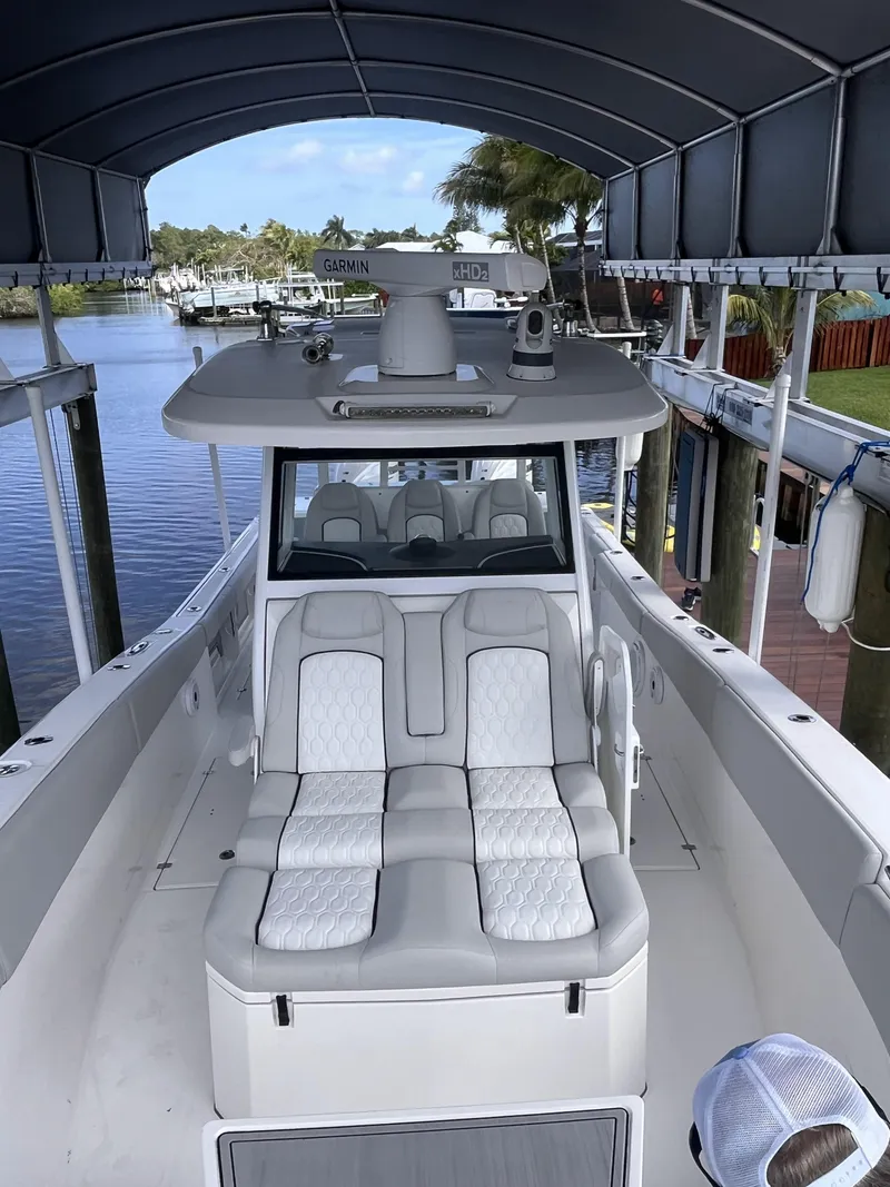 Slide: The Image of 2021 Sea Fox 368 Commander boat with cushioned seating, docked under a canopy. - 10