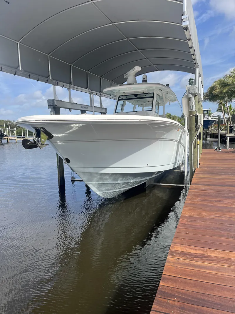 Slide: The Image of 2021 Sea Fox 368 Commander boat docked under a canopy on calm water. - 7