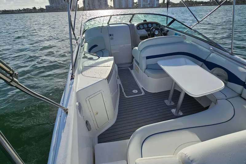 Slide: The Image of 2002 Chaparral 285 SSi boat interior with seating and table on calm water. - 10
