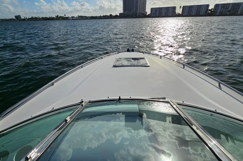 Slide: The Image of 2002 Chaparral 285 SSi boat cruising on a sunny day with city skyline in background. - 15