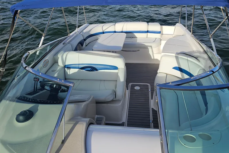 Slide: The Image of 2002 Chaparral 285 SSi boat interior with seating and table on water. - 16