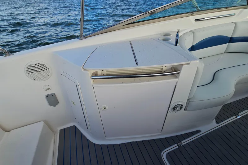 Slide: The Image of 2002 Chaparral 285 SSi boat interior with seating and storage, overlooking water. - 17