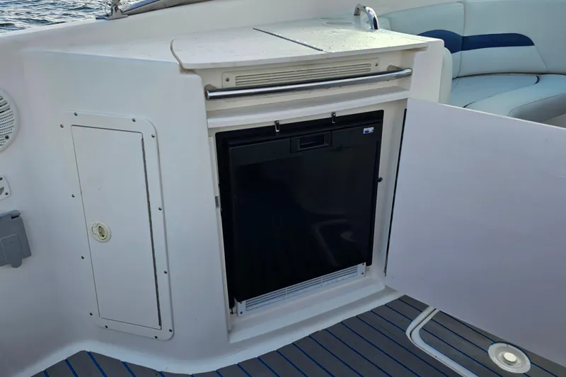 Slide: The Image of 2002 Chaparral 285 SSi boat interior with mini fridge and seating area. - 19