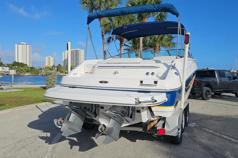 Slide: The Image of Chaparral 285 SSi 2002 boat on trailer by waterfront, clear sky, palm trees. - 2