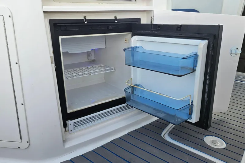Slide: The Image of Open mini fridge on 2002 Chaparral 285 SSi boat, showing interior shelves and door compartments. - 20
