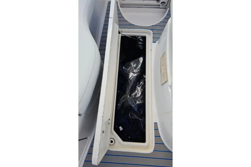 Slide: The Image of Open storage compartment on 2002 Chaparral 285 SSi boat, showing interior contents. - 21