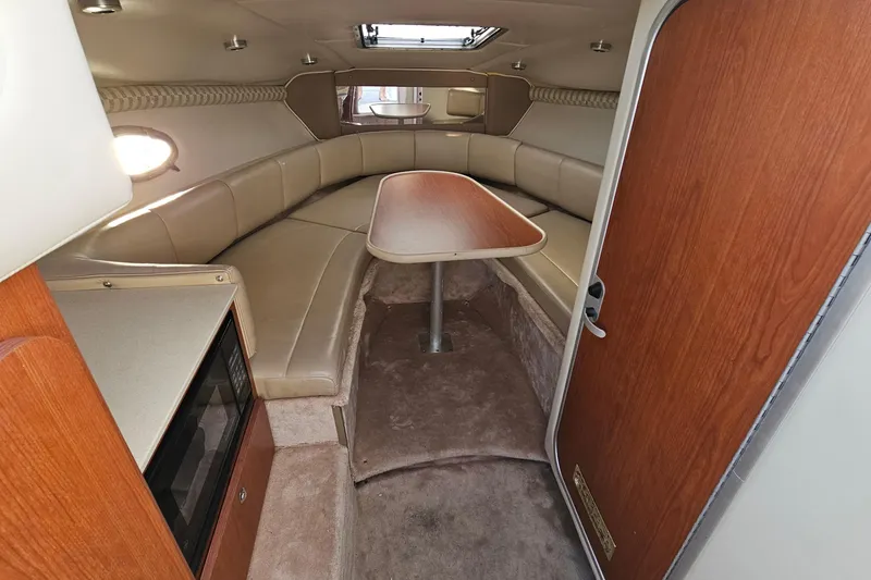 Slide: The Image of 2002 Chaparral 285 SSi cabin interior with seating, table, and kitchenette. - 24