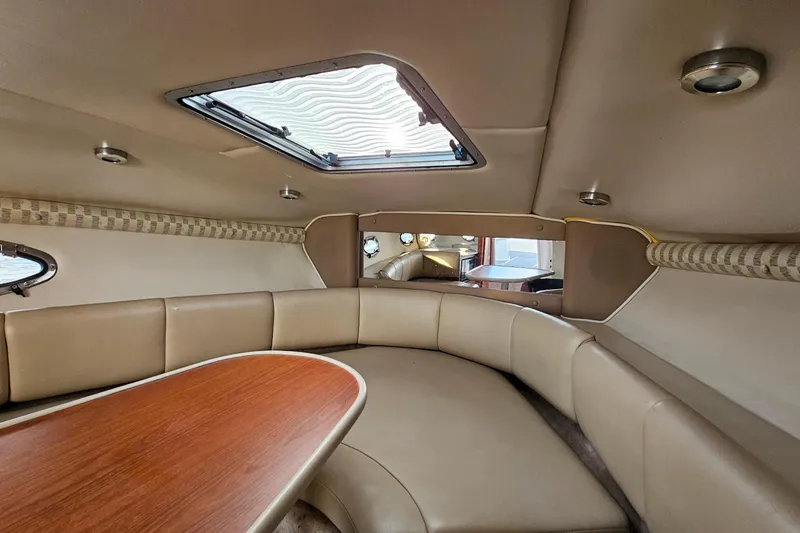 Slide: The Image of 2002 Chaparral 285 SSi boat interior with beige seating and wooden table. - 26