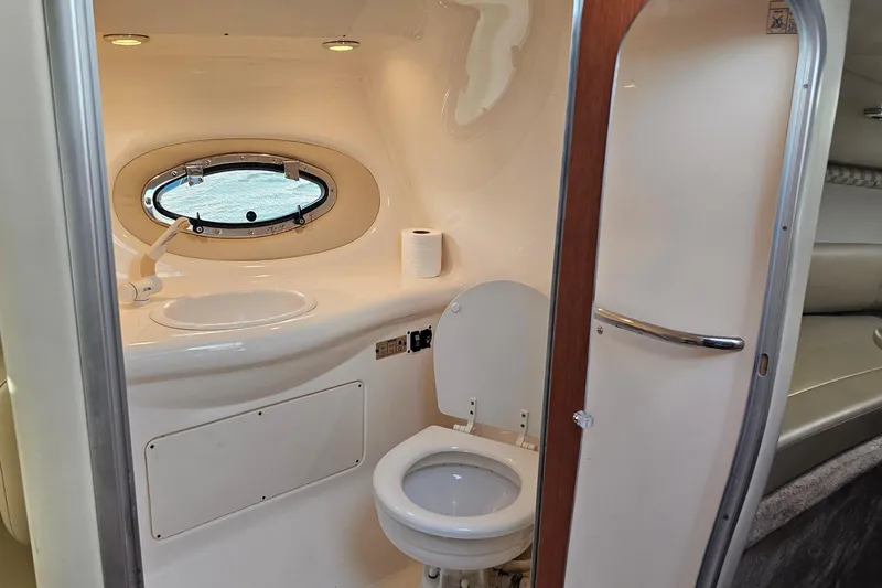 Slide: The Image of 2002 Chaparral 285 SSi boat bathroom with sink, toilet, and porthole window. - 28