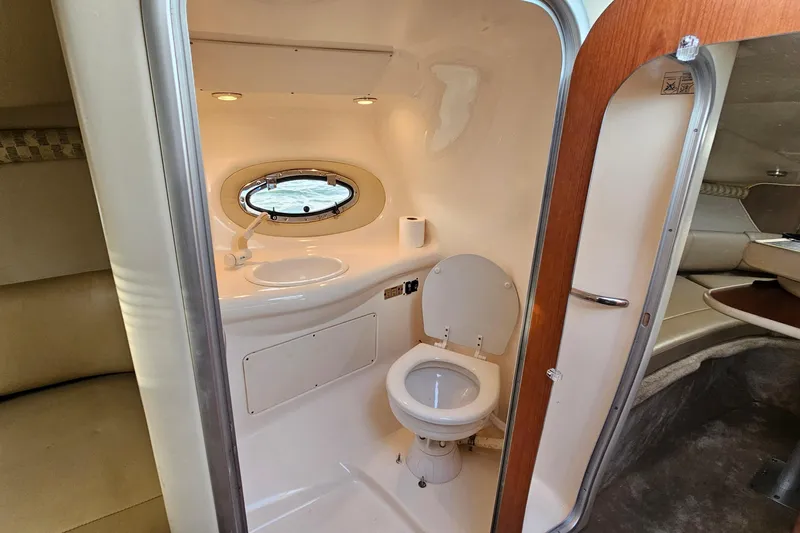 Slide: The Image of 2002 Chaparral 285 SSi boat bathroom with toilet, sink, and porthole window. - 29