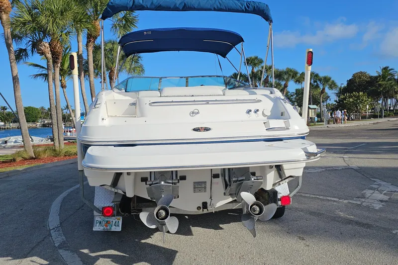 Slide: The Image of 2002 Chaparral 285 SSi boat with dual propellers, docked near palm trees and water. - 3