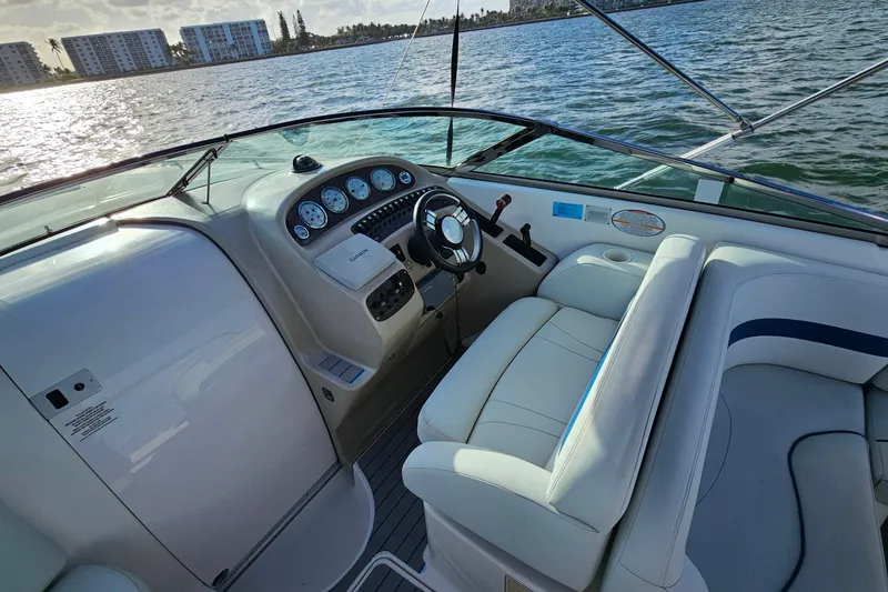 Slide: The Image of 2002 Chaparral 285 SSi boat interior with steering wheel and dashboard on calm water. - 7