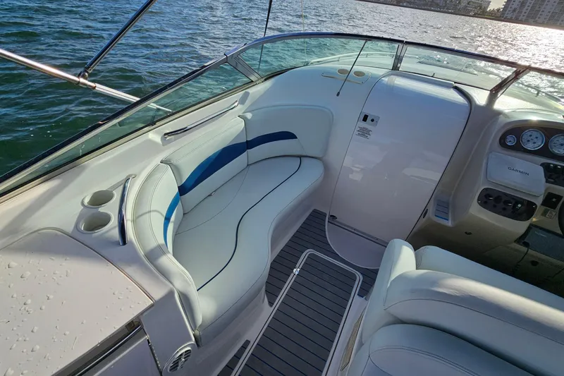 Slide: The Image of 2002 Chaparral 285 SSi boat interior with white seating and dashboard, on water. - 8