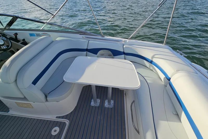 Slide: The Image of 2002 Chaparral 285 SSi boat interior with white and blue seating and table. - 9