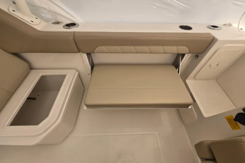 Slide: The Image of 2020 Sailfish 245 DC boat interior with beige seating and storage compartments. - 19