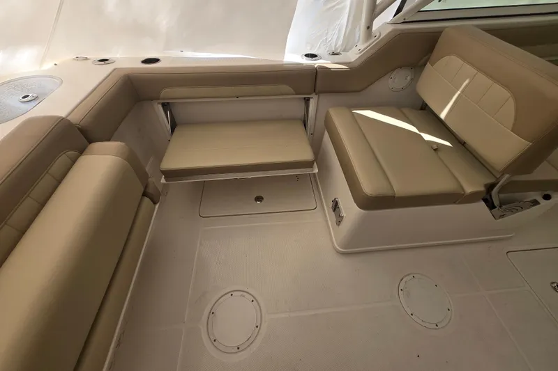 Slide: The Image of 2020 Sailfish 245 DC boat interior with beige seating and storage compartments. - 20