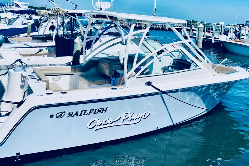 Slide: The Image of 2020 Sailfish 245 DC boat docked in marina, featuring sleek design and white exterior. - 21