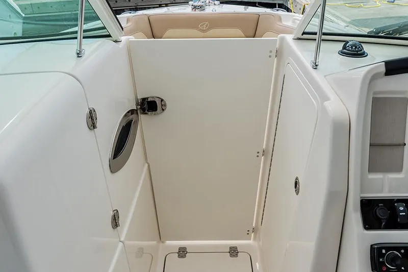 Slide: The Image of 2020 Sailfish 245 DC boat interior with beige seating and steering console. - 6