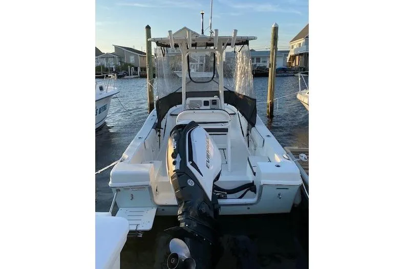 Slide: The Image of 2018 Clearwater 2000 Center Console boat docked, featuring an Evinrude outboard motor. - 2