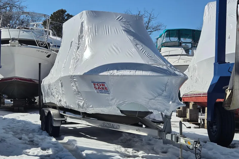 Slide: The Image of 2018 Clearwater 2000 Center Console boat, covered and for sale, on a snowy trailer. - 4